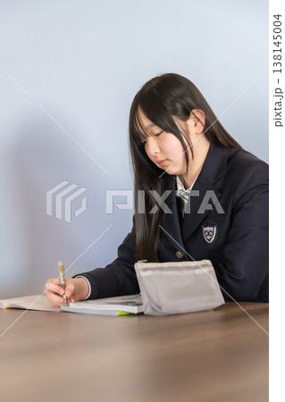 ノートに書き込みをする制服姿の女子中学生・高校生 勉強 学習イメージ 138145004
