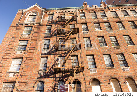 Historic brick apartment building facade with metal fire escape in New York City Historic brick apartment building facade with metal fire escape in New York City 138145026