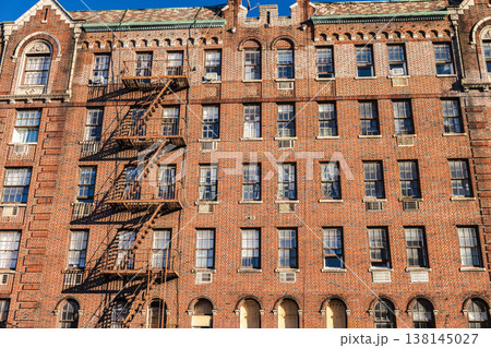Brick apartment building facade with fire escape stairs in New York city Brick apartment building facade with fire escape stairs in New York city 138145027