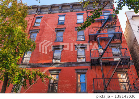 Red brick New York residential building facade with metal fire escape stairs Red brick New York residential building facade with metal fire escape stairs 138145030