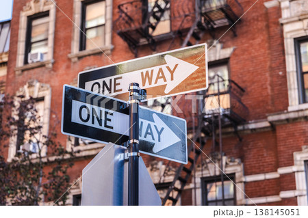 One way street signs at city intersection with classic New York brick buildings One way street signs at city intersection with classic New York brick buildings 138145051