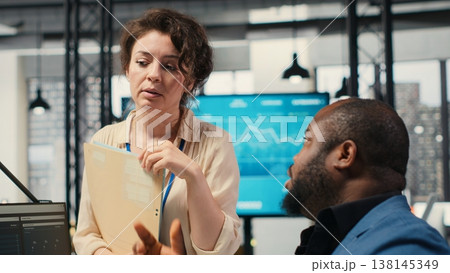 Colleagues engaging in discussion and consulting around performance metrics, leveraging insights to align objectives and achieve business goals efficiently in a multinational company. Camera B. Colleagues engaging in discussion and consulting around performance metrics, leveraging insights to align objectives and achieve business goals efficiently in a multinational company. Camera B. 138145349