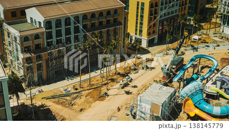 Aerial view of resort construction site with heavy machinery and partially built structures Aerial view of resort construction site with heavy machinery and partially built structures 138145779