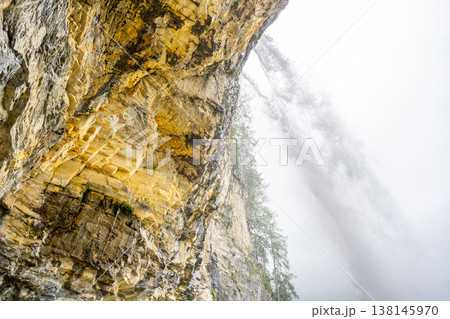 Johannes Waterfall flows dramatically down rocky cliffs surrounded by lush greenery in Obertauern, Austria. Mist envelops the scene, creating a serene atmosphere. Johannes Waterfall flows dramatically down rocky cliffs surrounded by lush greenery in Obertauern, Austria. Mist envelops the scene, creating a serene atmosphere. 138145970