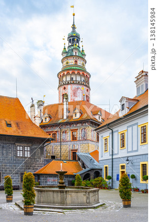 The photo shows a castle tower in Cesky Krumlov. It is a summer day, and people visit the historic town. The architecture reflects the unique style of the area. The photo shows a castle tower in Cesky Krumlov. It is a summer day, and people visit the historic town. The architecture reflects the unique style of the area. 138145984