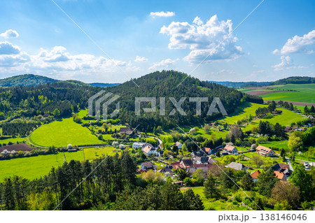 Rabi Castle offers a view of the surrounding landscape in Bohemia. Green hills and fields stretch into the distance with small houses nestled below. Clouds float in the blue sky. Rabi Castle offers a view of the surrounding landscape in Bohemia. Green hills and fields stretch into the distance with small houses nestled below. Clouds float in the blue sky. 138146046