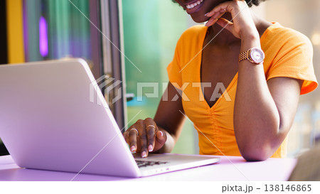 Woman using laptop with smile at a bright cafe during the afternoon 138146865