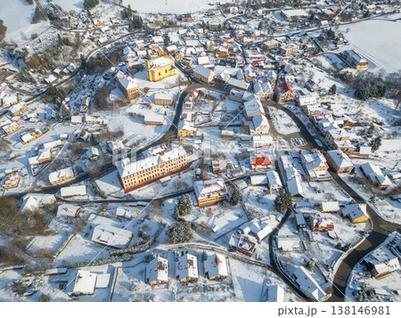 Pecka town is covered in snow during winter. This aerial view shows the layout of streets and buildings, with many rooftops blanketed in white. The scene captures the town's winter beauty. Pecka town is covered in snow during winter. This aerial view shows the layout of streets and buildings, with many rooftops blanketed in white. The scene captures the town's winter beauty. 138146981