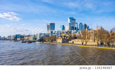 View of London skyline featuring the iconic Tower and modern skyscrapers along the River Thames. The scene captures the beauty of the city against a clear blue sky. 138146987