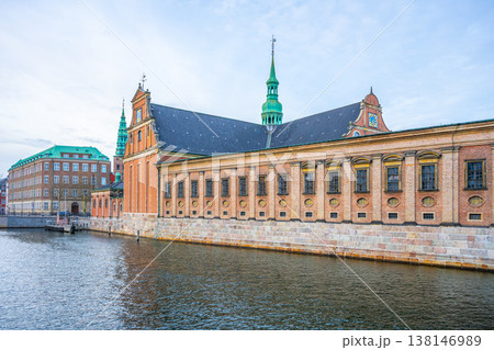 Holmen Church is located in central Copenhagen, Denmark. The building features green spires and brick walls. It sits next to the water under a cloudy sky. Holmen Church is located in central Copenhagen, Denmark. The building features green spires and brick walls. It sits next to the water under a cloudy sky. 138146989