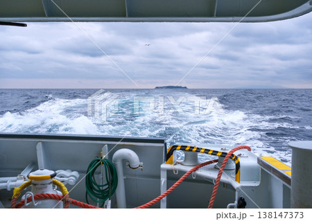 曇天の日初島から熱海へ向かうフェリーの船尾から見える島 138147373