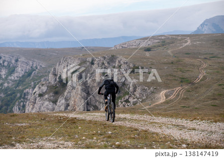 Mountain biker riding along winding trail 138147419
