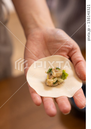 餃子の餡を皮で包む手元のクローズアップ 138148321