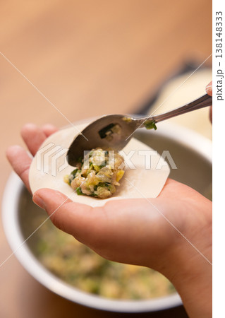 餃子の餡を皮で包む手元のクローズアップ 138148333
