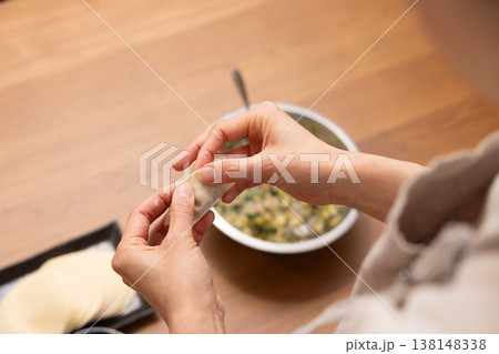 餃子の餡を皮で包む手元のクローズアップ 138148338