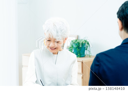 営業マンの説明を聞くシニア女性 138148410
