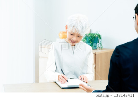 営業マンの説明を聞くシニア女性 138148411