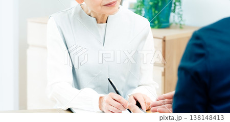 営業マンの説明を聞くシニア女性 138148413