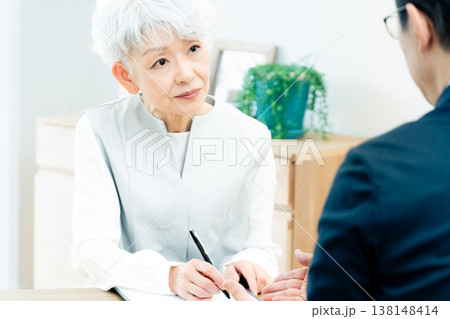 営業マンの説明を聞くシニア女性 営業マンの説明を聞くシニア女性 138148414