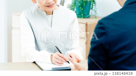 営業マンの説明を聞くシニア女性 138148419