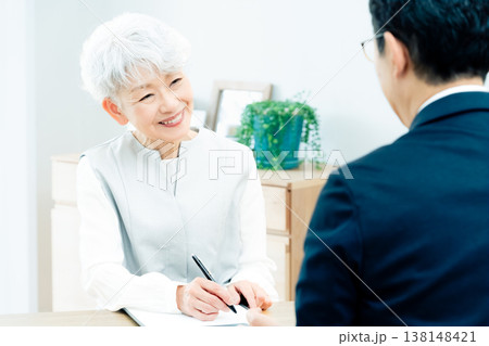 営業マンの説明を聞くシニア女性 営業マンの説明を聞くシニア女性 138148421