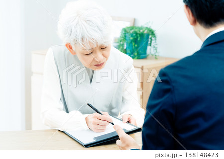 営業マンの説明を聞くシニア女性 138148423