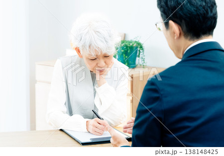 営業マンの説明を聞くシニア女性 138148425
