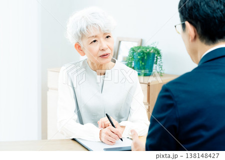 営業マンの説明を聞くシニア女性 138148427