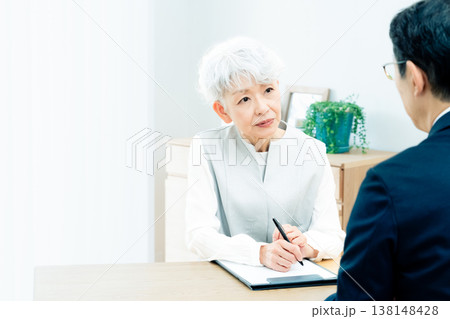 営業マンの説明を聞くシニア女性 138148428