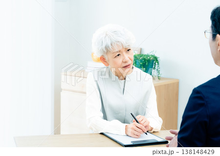 営業マンの説明を聞くシニア女性 138148429