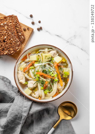 Chicken noodle soup with fresh dill in a bowl on a white marble background Chicken noodle soup with fresh dill in a bowl on a white marble background 138149722