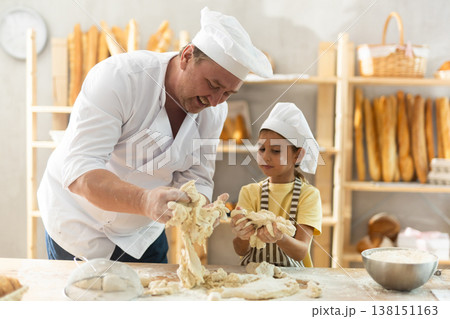 Father and daughter roll out dough together to make delicious bread Father and daughter roll out dough together to make delicious bread 138151163