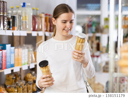 woman chooses canned corn in a store 138151179
