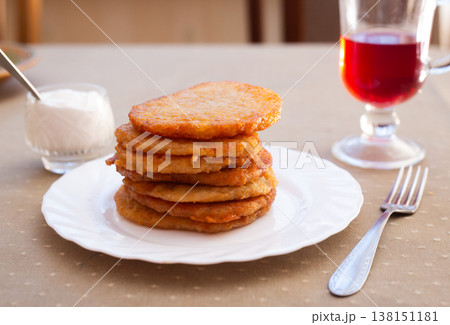 Crispy Potato Fritters Layered on Porcelain Dish 138151181