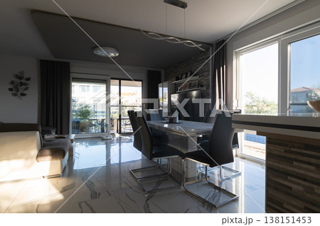 Modular house interior with modern dining area and smart vacuum cleaner at sunset Modular house interior with modern dining area and smart vacuum cleaner at sunset 138151453