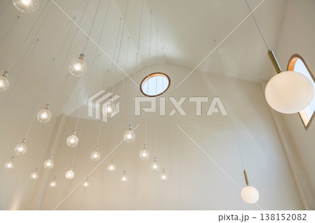 Modern light bulbs haging on high ceiling of cafes building Modern light bulbs haging on high ceiling of cafes building 138152082