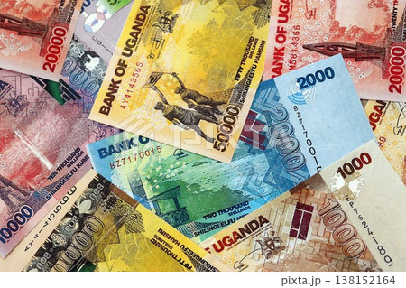 Ugandan shilling paper banknotes pile on table. Uganda UGX currency money bills in big amount. Concept of economics, taxation and banking in Uganda 138152164