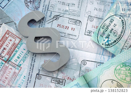 Paragraph symbol on passport pages full of colorful stamps after travel and tourism. Border control and lawsuit concept. Immigration and travel around the world Paragraph symbol on passport pages full of colorful stamps after travel and tourism. Border control and lawsuit concept. Immigration and travel around the world 138152823