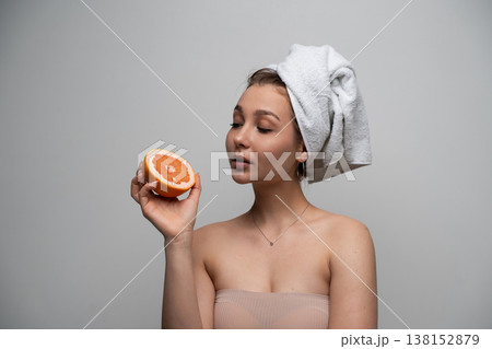 Young woman enjoying fresh natural skincare ingredients, holding grapefruit half, promoting healthy beauty routine and wellness Young woman enjoying fresh natural skincare ingredients, holding grapefruit half, promoting healthy beauty routine and wellness 138152879