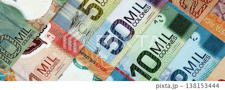 Costa Rican old and new colon money bills pile on table. Costa Rica banknotes of CRC currency close up. Concept of business, economy and banking in Costa Rica Costa Rican old and new colon money bills pile on table. Costa Rica banknotes of CRC currency close up. Concept of business, economy and banking in Costa Rica 138153444