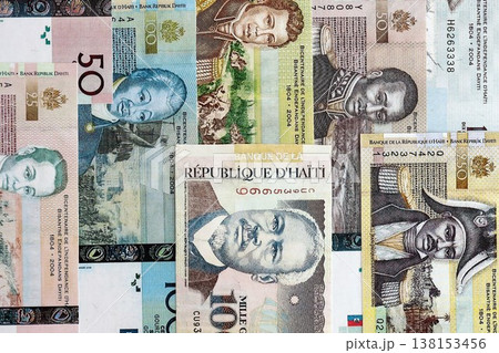 Haitian gourde money bills pile on table. Haiti banknotes of HTG currency close up. Concept of business, economy and banking in Haiti Haitian gourde money bills pile on table. Haiti banknotes of HTG currency close up. Concept of business, economy and banking in Haiti 138153456