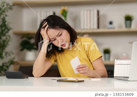 Woman stressed over financial calculations Woman stressed over financial calculations 138153609
