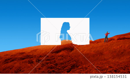 Woman walking near paper human silhouette cutout in red grass surreal landscape Woman walking near paper human silhouette cutout in red grass surreal landscape 138154531