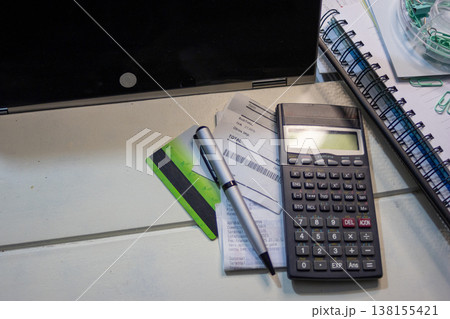 Desktop workspace with a laptop, calculator, credit card, illustrating financial planning. Managing expenses for online work 138155421