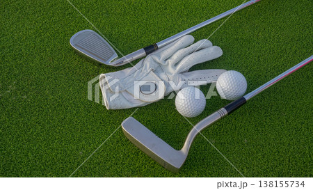Golf clubs and balls on a green lawn in a beautiful golf course with morning sunshine. 138155734