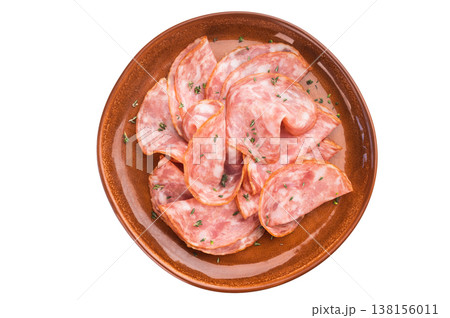 Sliced salami sausage served on ceramic plate with herbs on isolated background. Italian cured pork charcuterie with copy space. Sliced salami sausage served on ceramic plate with herbs on isolated background. Italian cured pork charcuterie with copy space. 138156011