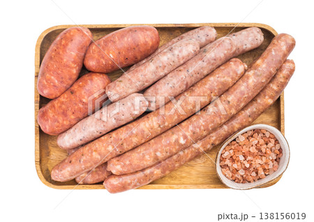 Assorted raw sausages on wooden tray with rosemary and coarse salt. Fresh pork meat links ready for grilling barbecue. 138156019