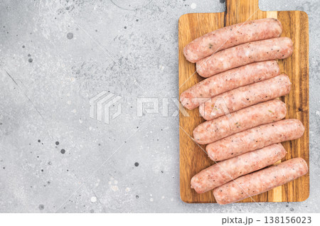 Fresh homemade pork sausages with thyme and pepper on wooden board, raw butcher style sausage links. Fresh homemade pork sausages with thyme and pepper on wooden board, raw butcher style sausage links. 138156023