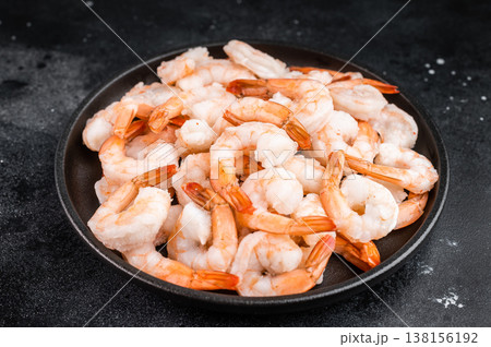 Icy peeled shrimp ready for defrosting and cooking. Frozen seafood portion on dark surface with copy space.. 138156192