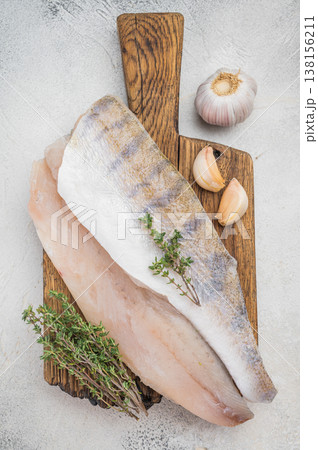 Raw pike perch fillets on light background with garlic and thyme, fresh lean freshwater white fish ready for cooking. Raw pike perch fillets on light background with garlic and thyme, fresh lean freshwater white fish ready for cooking. 138156211